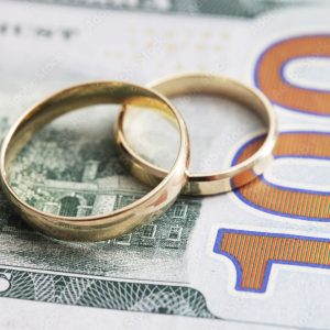 image of wedding rings atop $100 bill